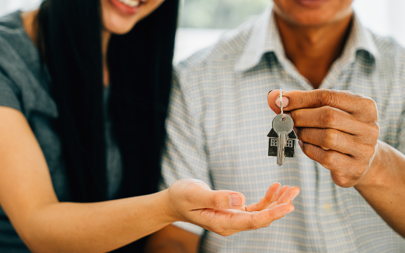 Man handing keys to woman