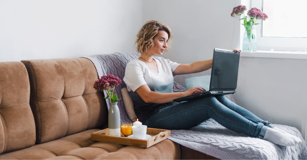 woman on couch working on computer