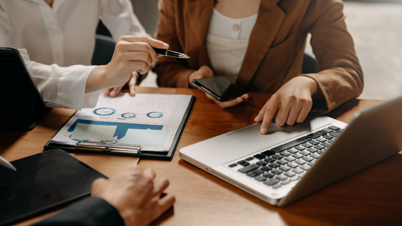 people with paperwork and computer